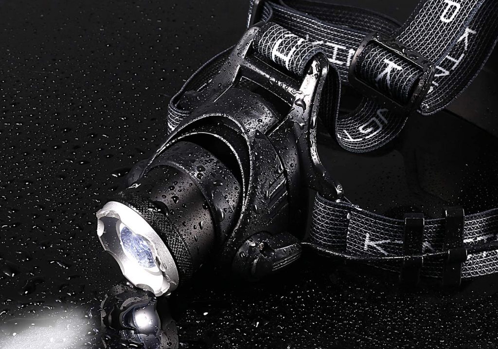 A black headlamp with speckles of rain on it.