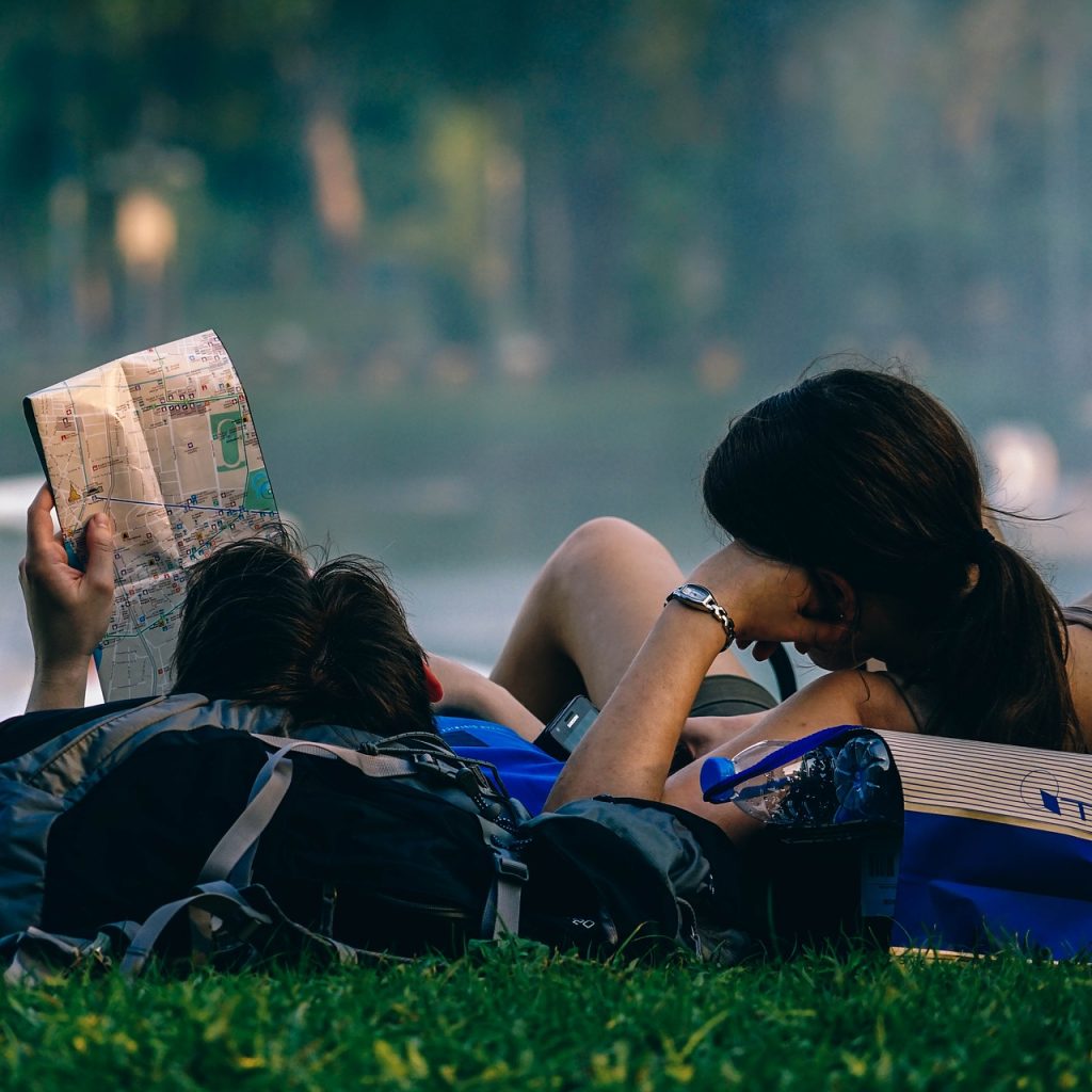 Travel friends taking a rest to plan the next stop on their road trip