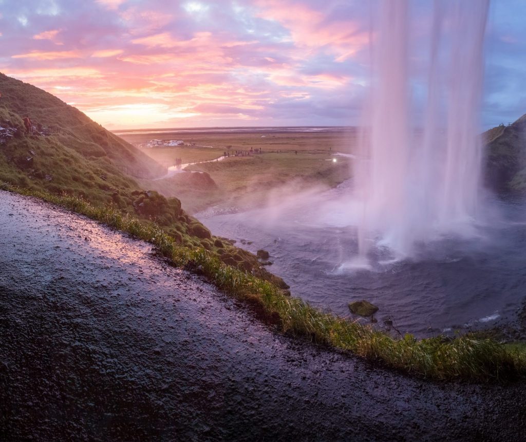 a waterfall under the purple sky.