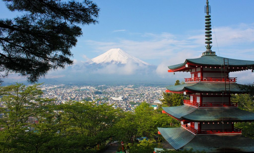 A mountain view of Japan with a traditional red Japanese building for a unique alternative to your traditional Christmas