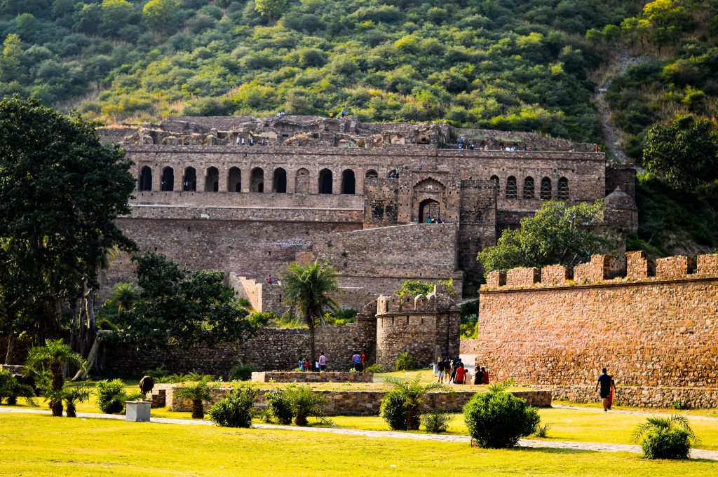 Bhangarh Fort in Rajasthan, India during the day time with luscious greenery around.