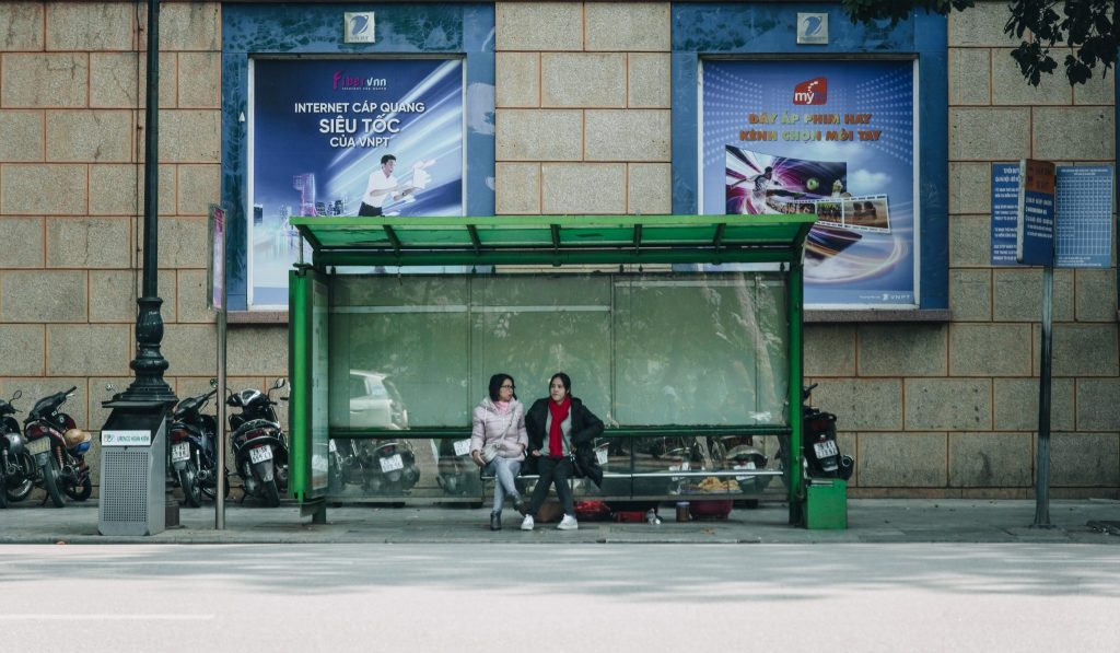 A green bus stop with 2 women in Finland.