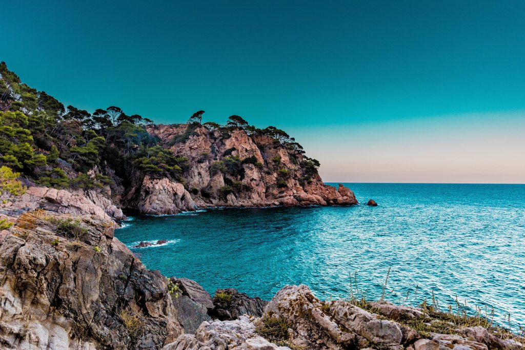 A blue sea view of Spain from a cliff.