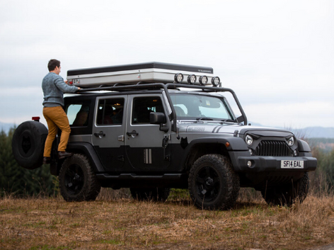 traveling with professional tour guides man standing on his car in Scotland 