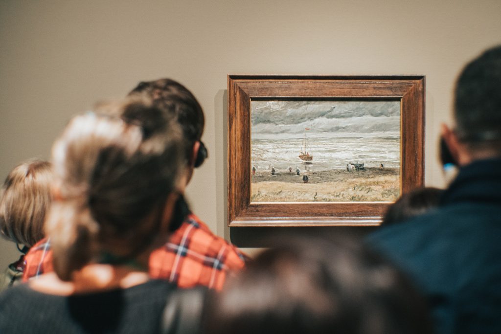 People looking at a piece of Van Gogh's art at a museum