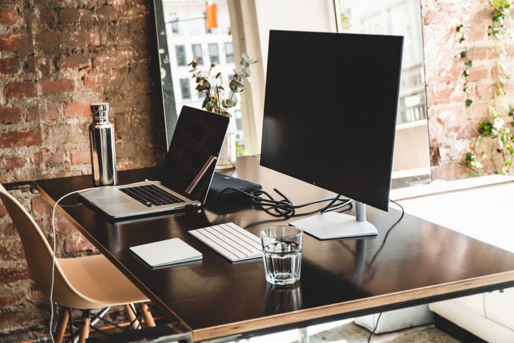 the best coworking spaces in 2021 are ones with a laptop and desktop on top of a black table. 