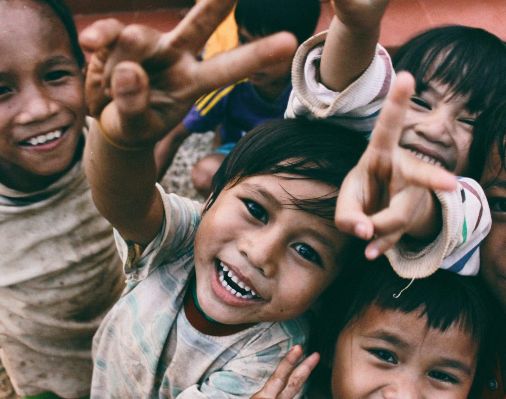 4 kids holding the peace sign infront of the camera and is a fun way to go abroad.