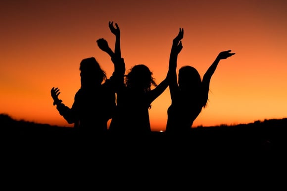 silhouette of three women, while traveling in the beautiful sunset