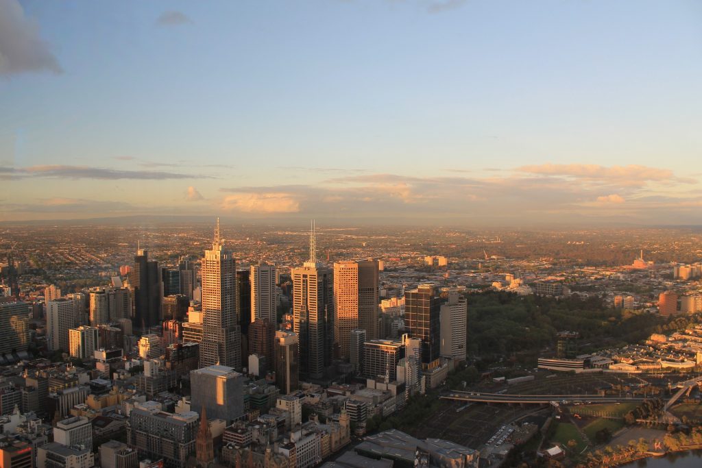 a view of Melbourne city skyscrapers and buildings with the sun light shining on them.