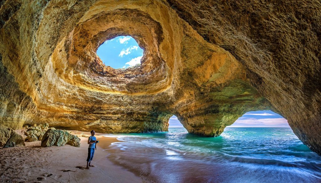 A person standing at a beach in a cove in Portugal