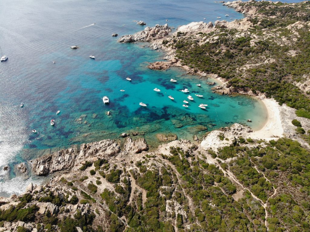 Ships on crystal clear beaches and rocky shores