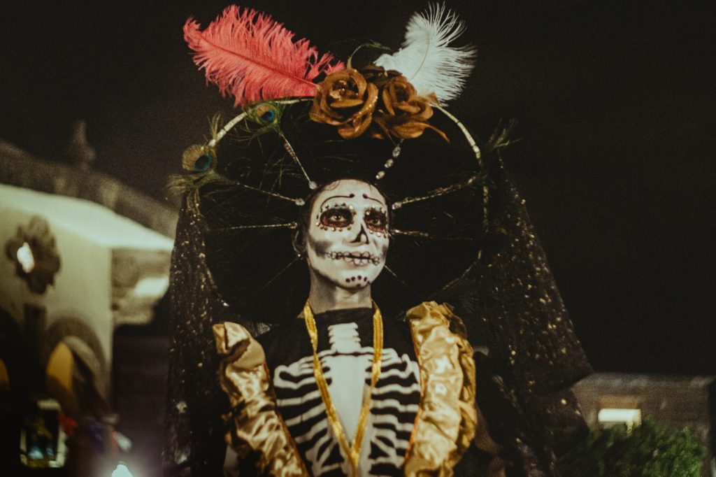 a woman in her costume and face paint which represents the dia de los Muertos 