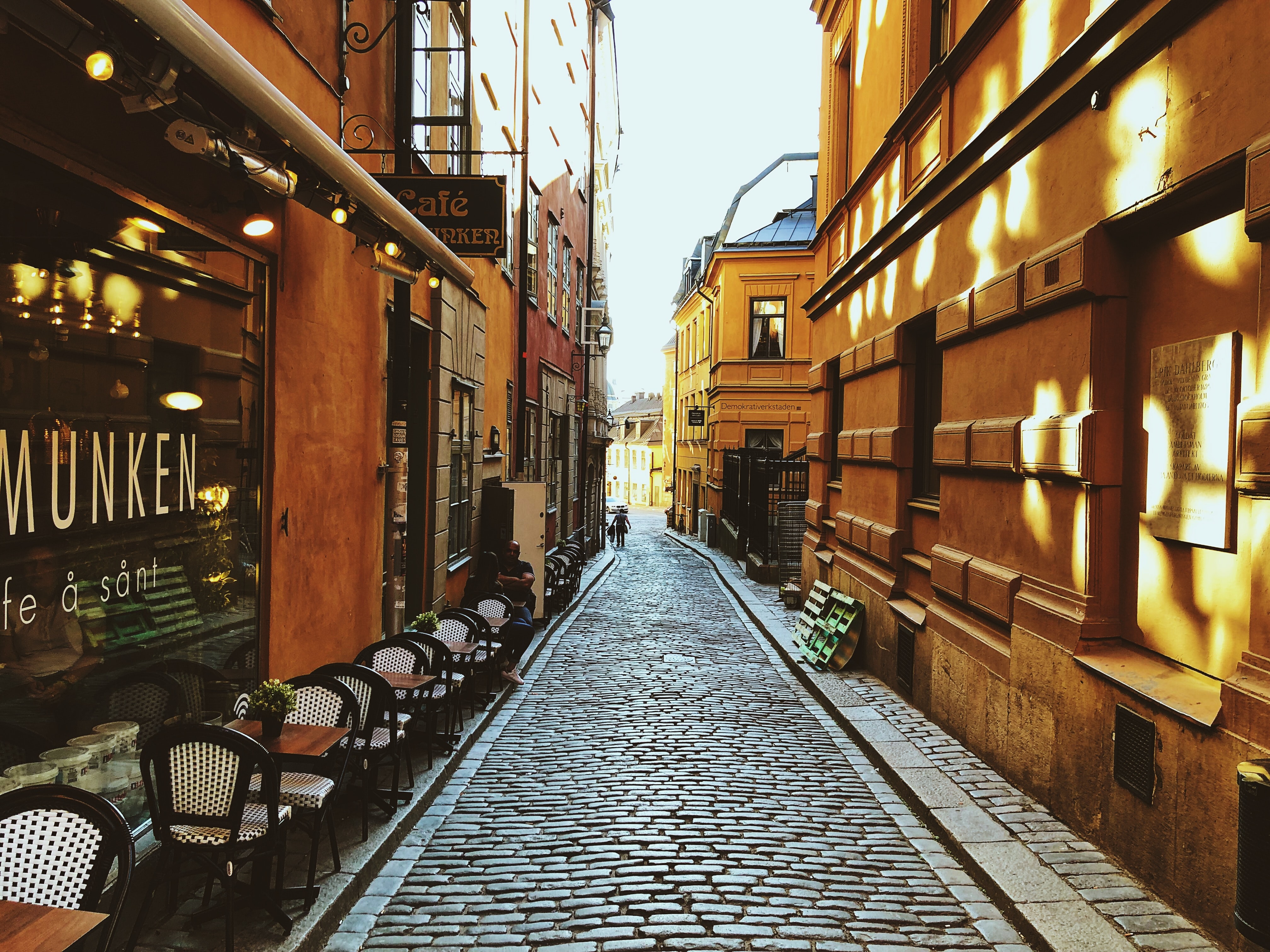 A view of the Swedish old town with yellow buildings and a cafe.