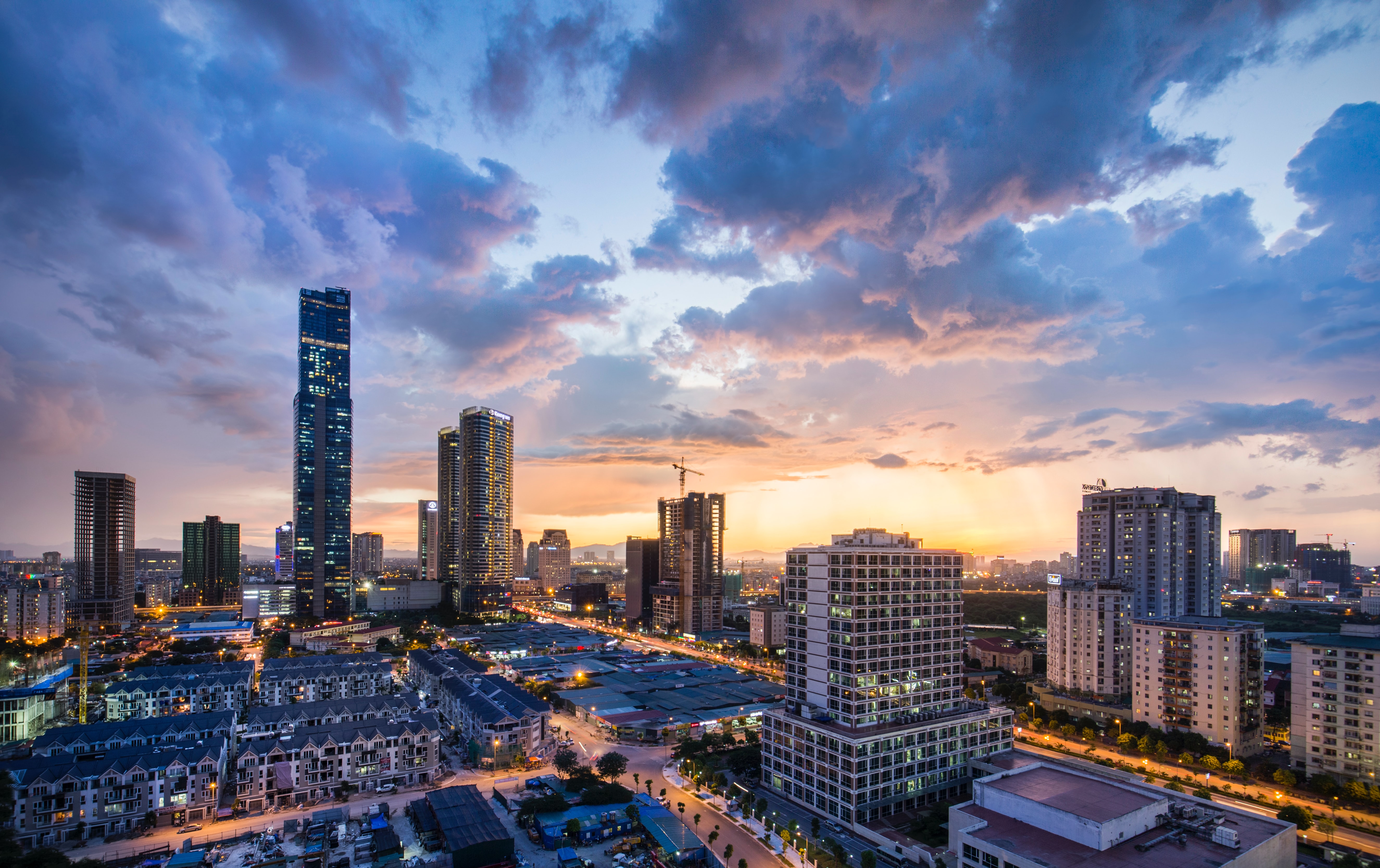 Hanoi city during the sunset with high buildings in the distance.