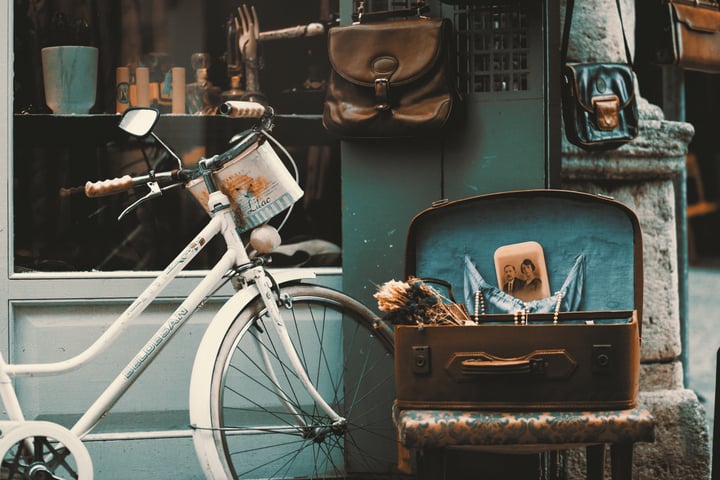 a bike and a suitcase in front of a store