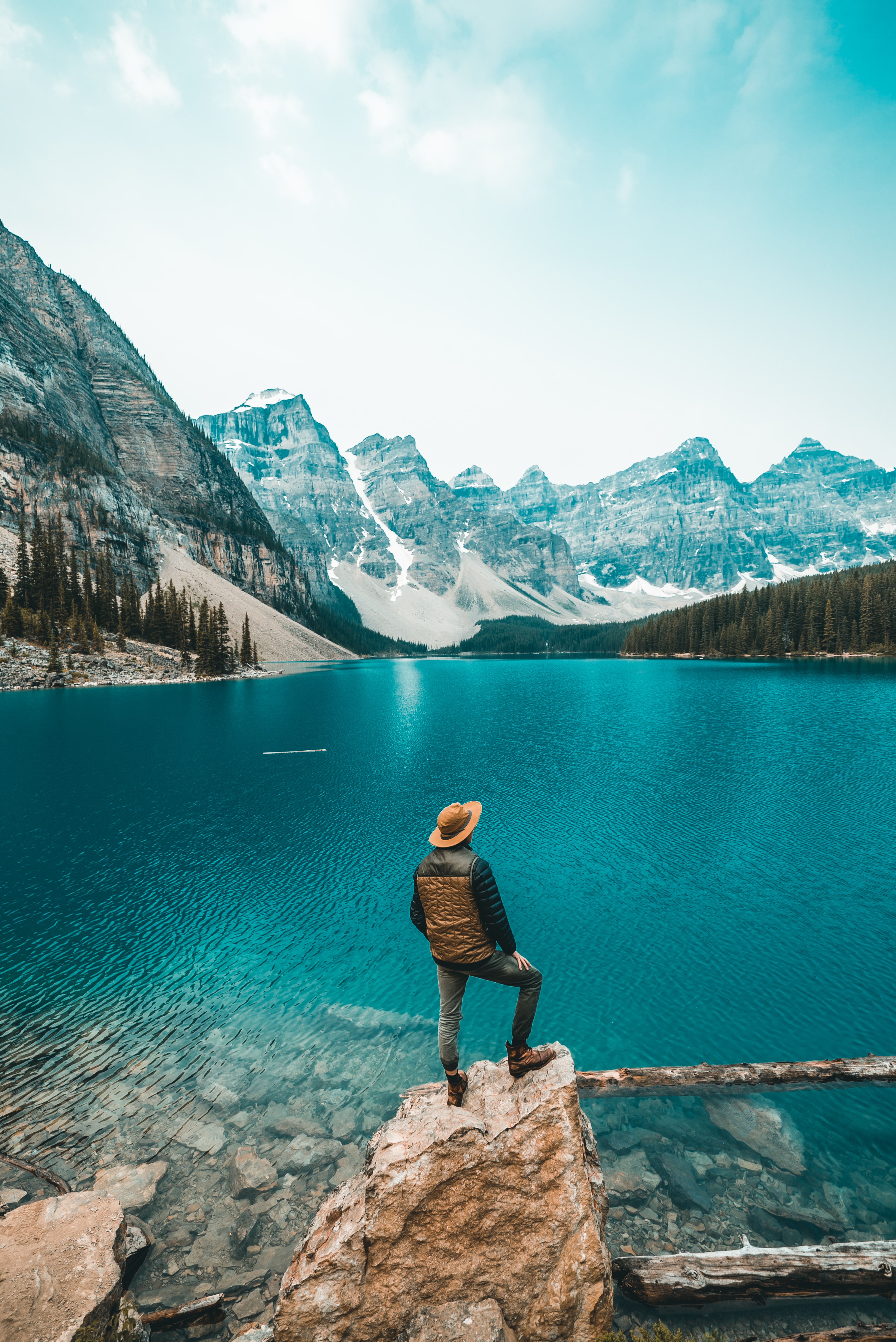 A man standing on top of a rock staring out into the blue sea in Canada.