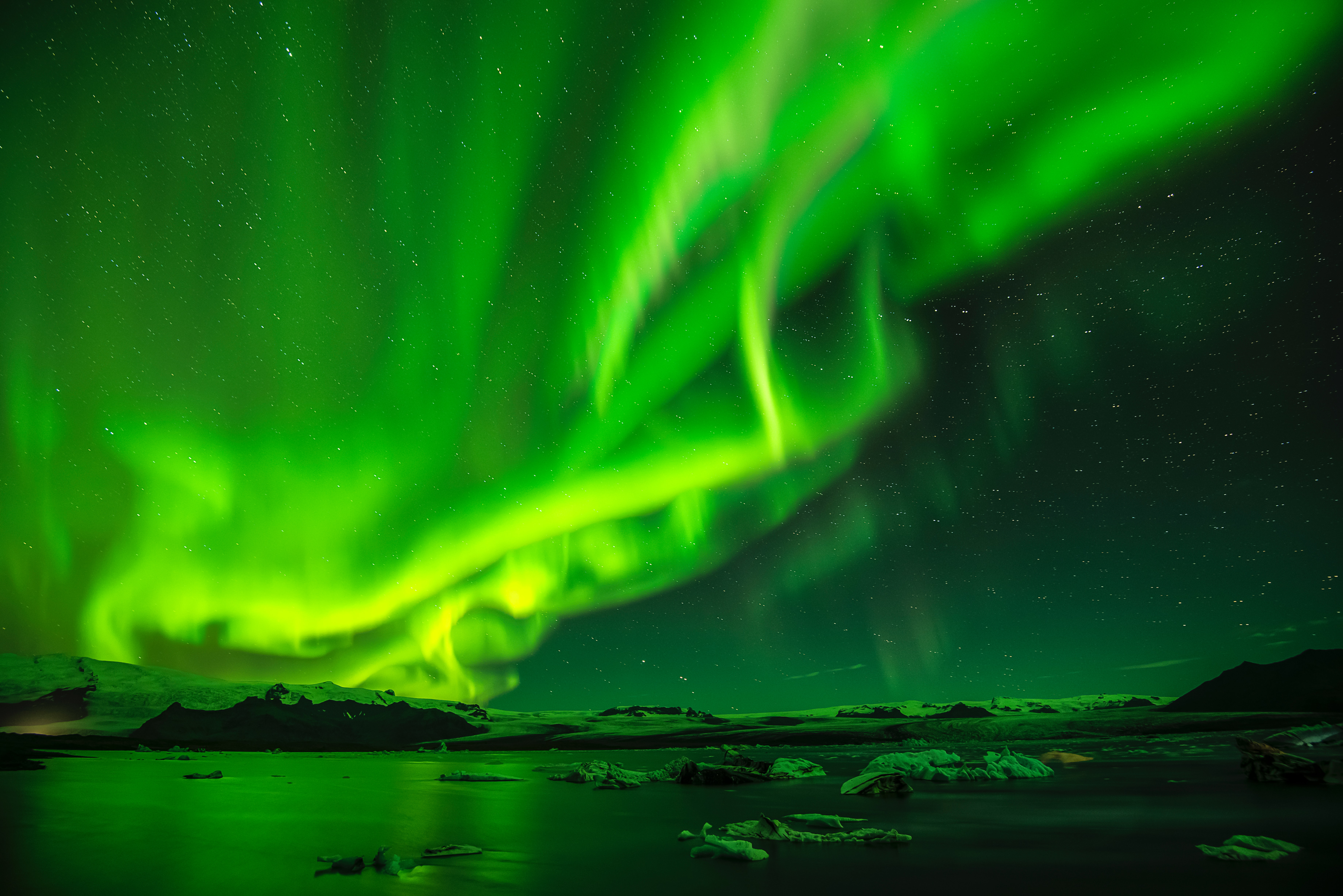 Northern lights over lake and mountains