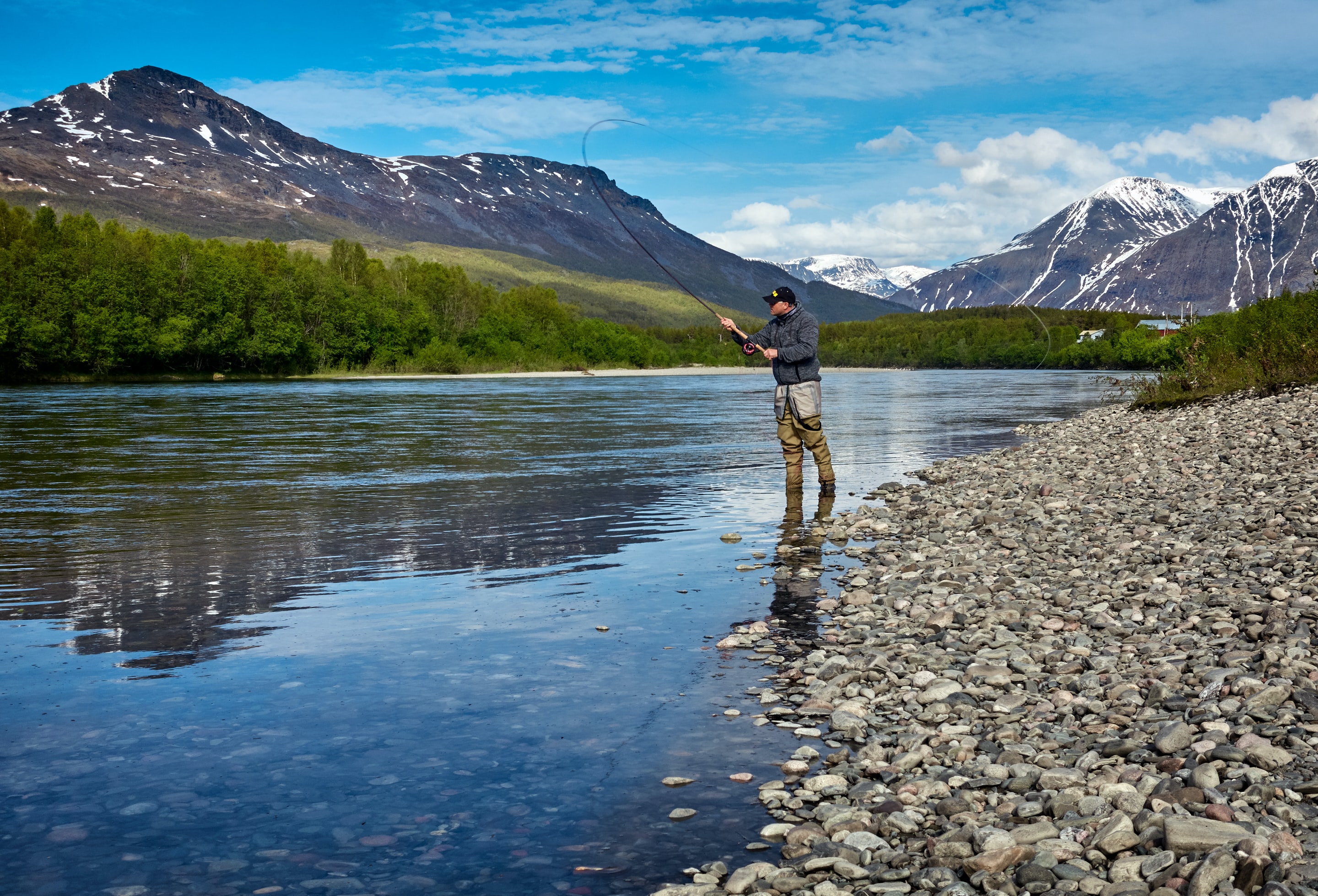 Man fishing on a river in the mountains