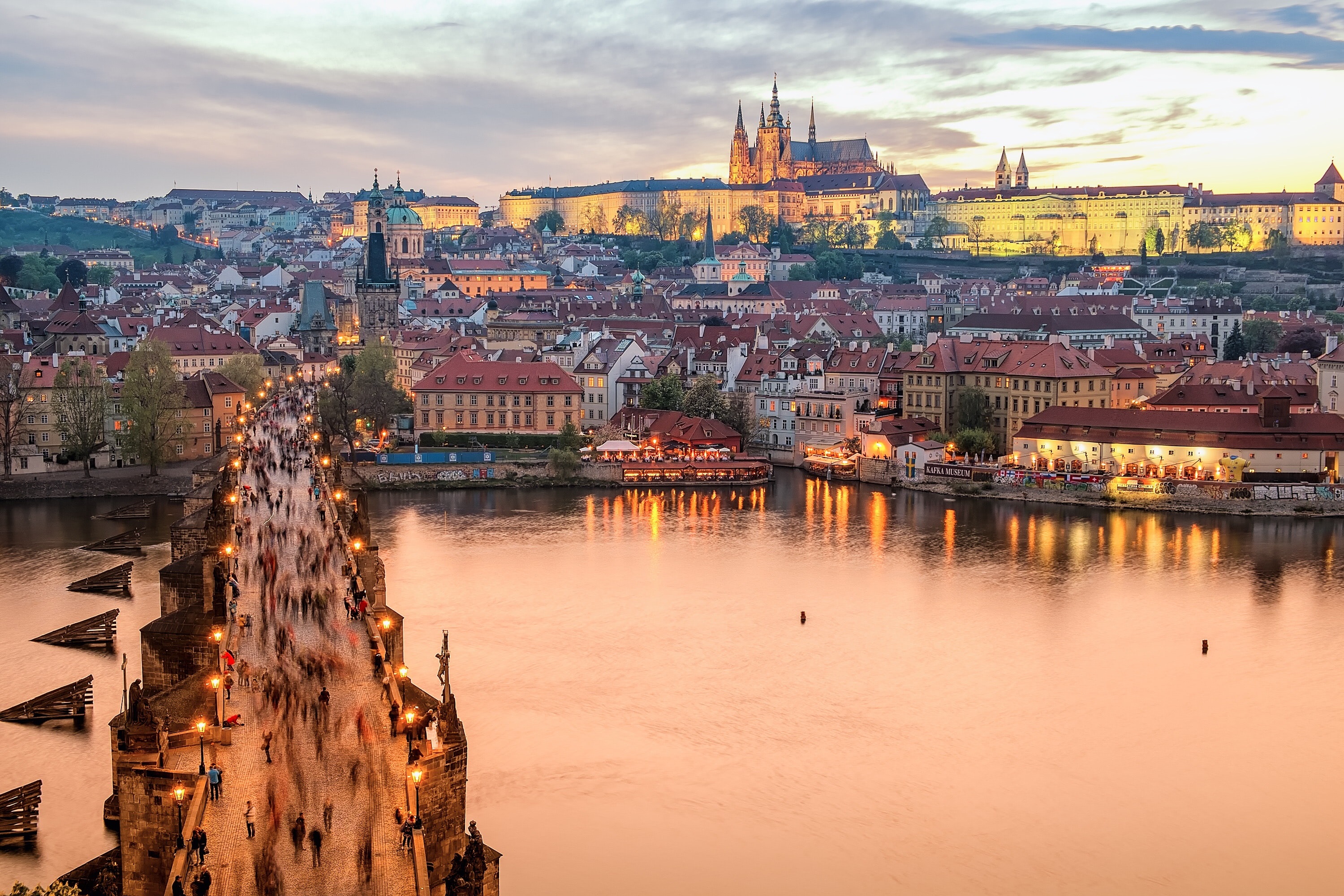 People walking over a bridge on a river in an old town