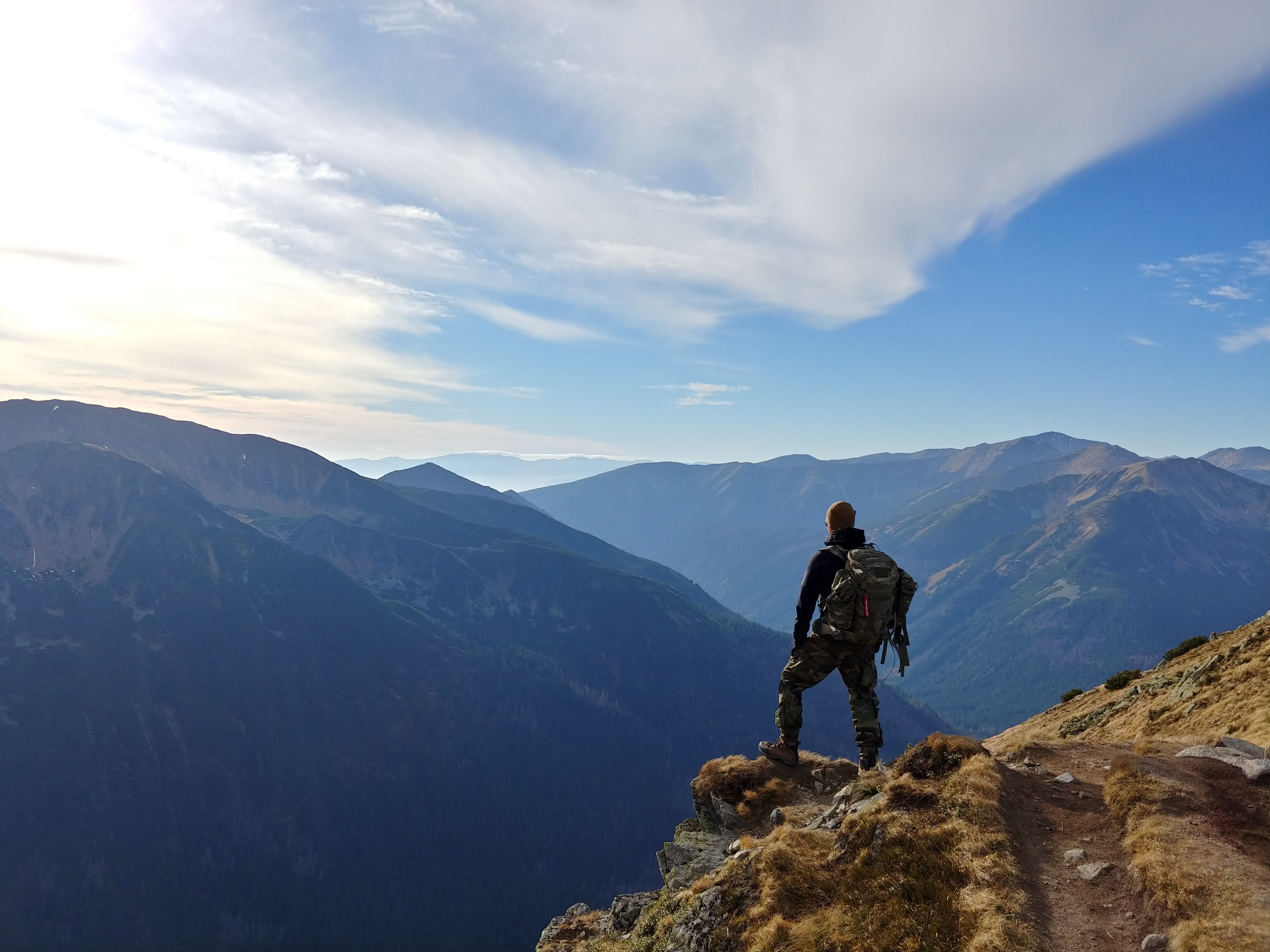 A person looking out into blue mountains