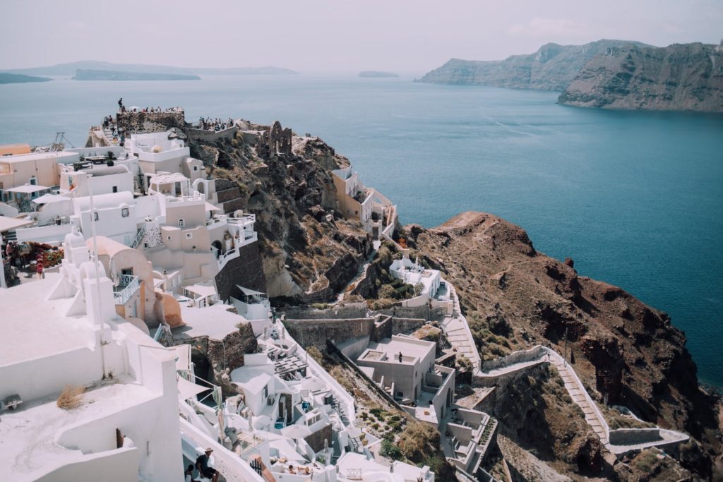 Traditional Greek buildings on a cliff looking over the water autumn destination in Europe