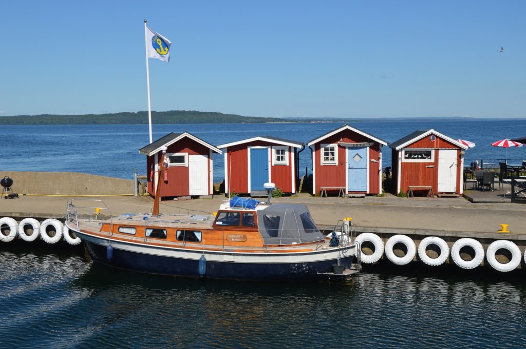 little huts, a boat, a flag by the sea while remote working