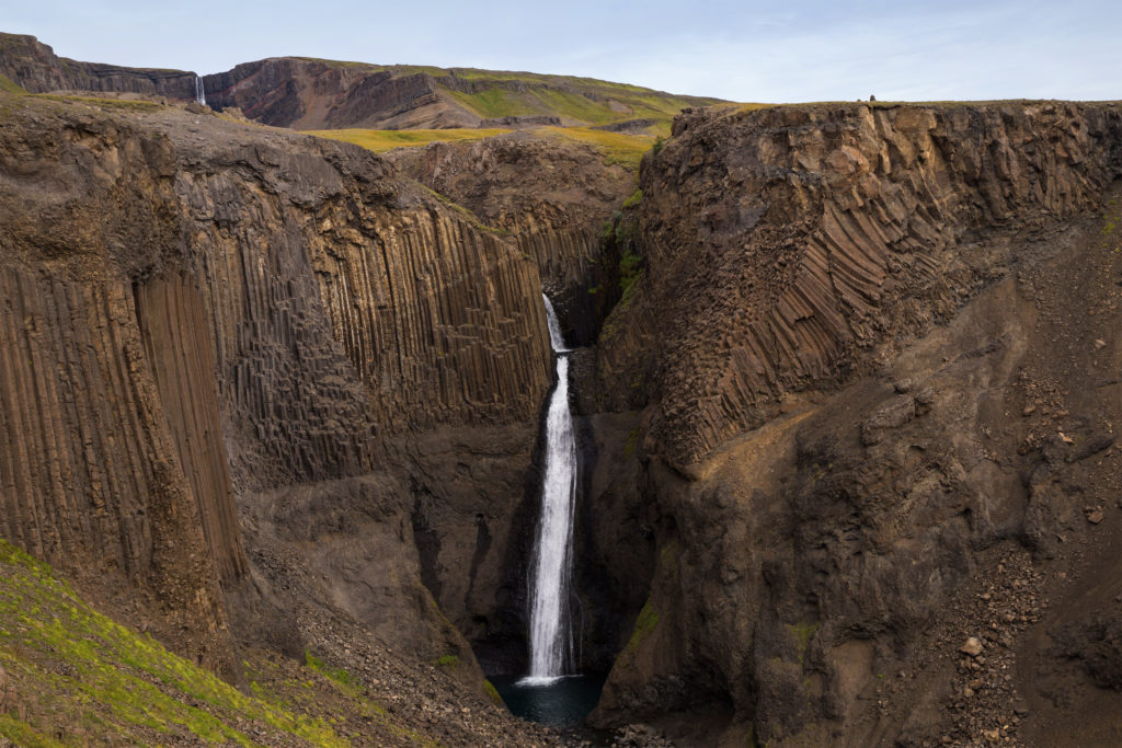 a waterfall in the midst of mountains why you should start booking spring 2021