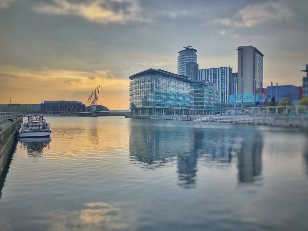 A huge river with a boat and a building in the background in one of the cheapest New Year destinations Manchester 