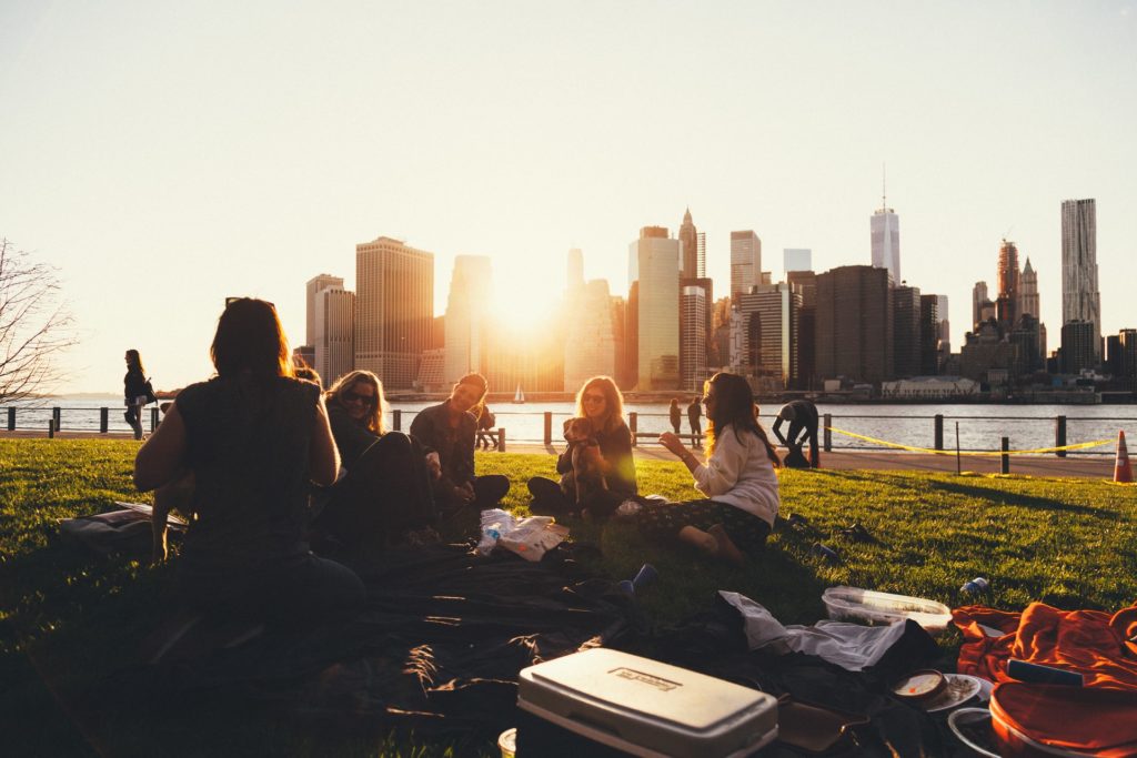 group of friends traveling together, sitting in a circle chatting to eachother in front of buildings 