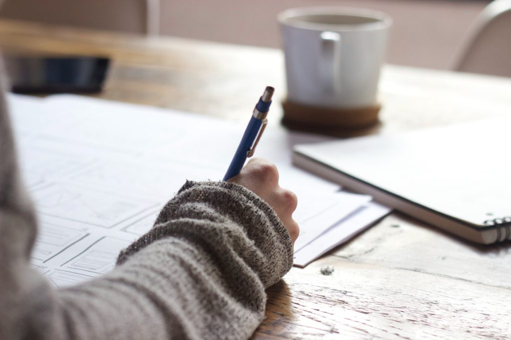 person at a desk writing 