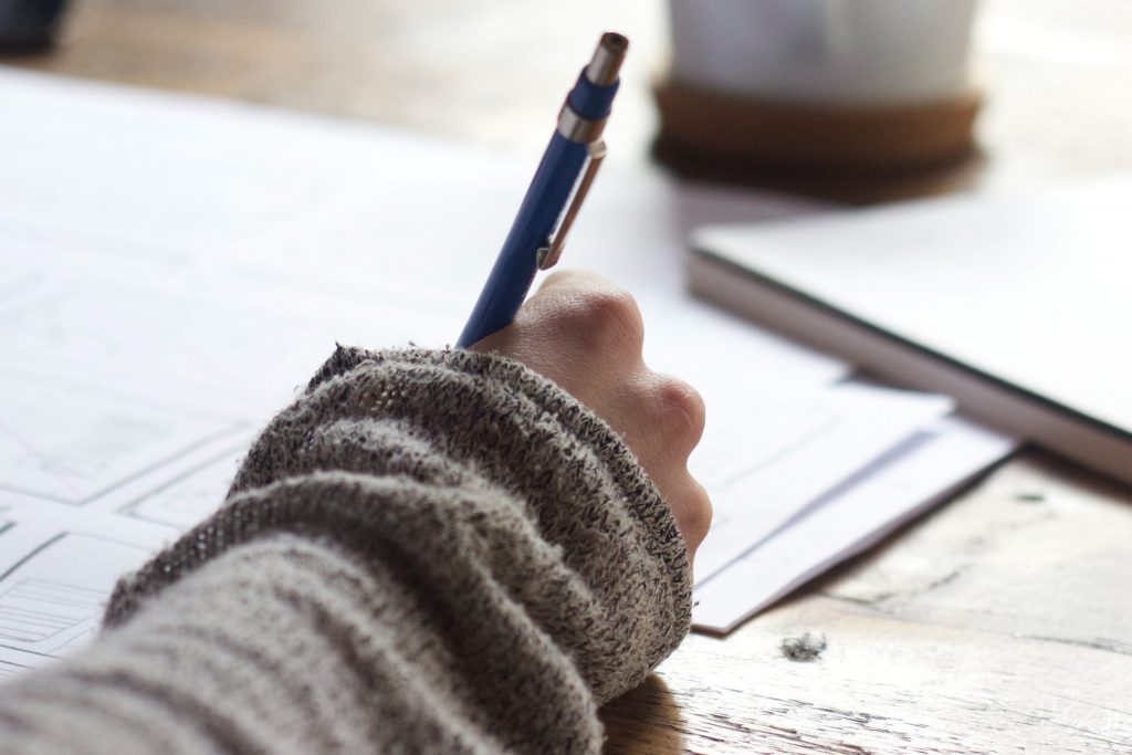 a woman writing notes with a pen