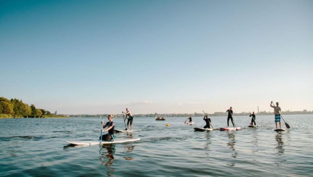 Group of people in the water paddling on a bard in Holsteiner Schweiz