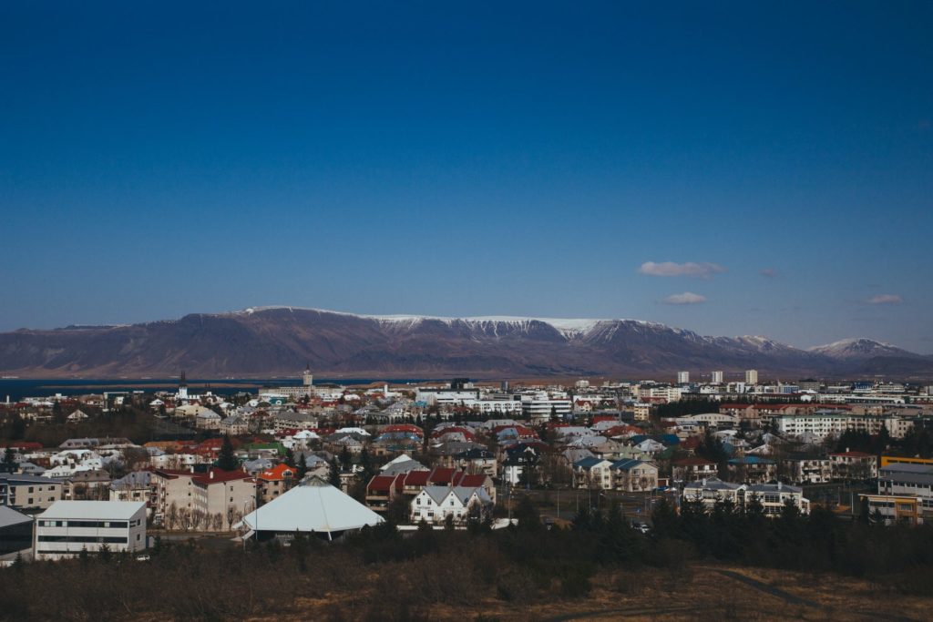 houses infront of a mountain with snow on top and blue skies while remote working