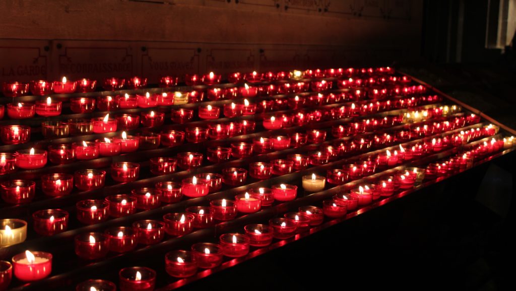 rows of red candles that have been already lit easter