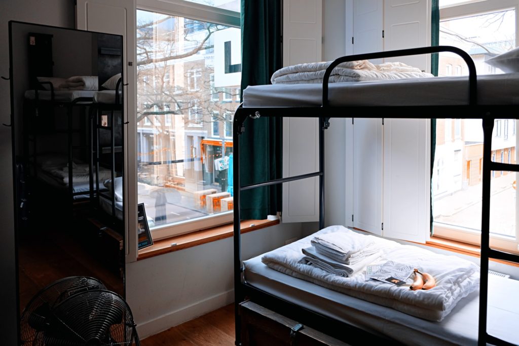 a picture of bunk beds in a hostel in a city which is perfect accomodation for a short trip