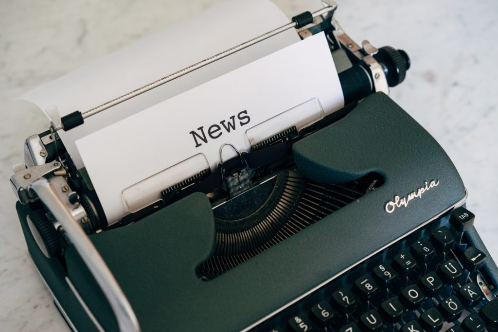 a typewriter with a sheet that reads news