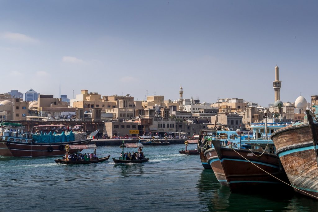 Dubai Creek in the Emirates: little boats on the water with the city in the background. 