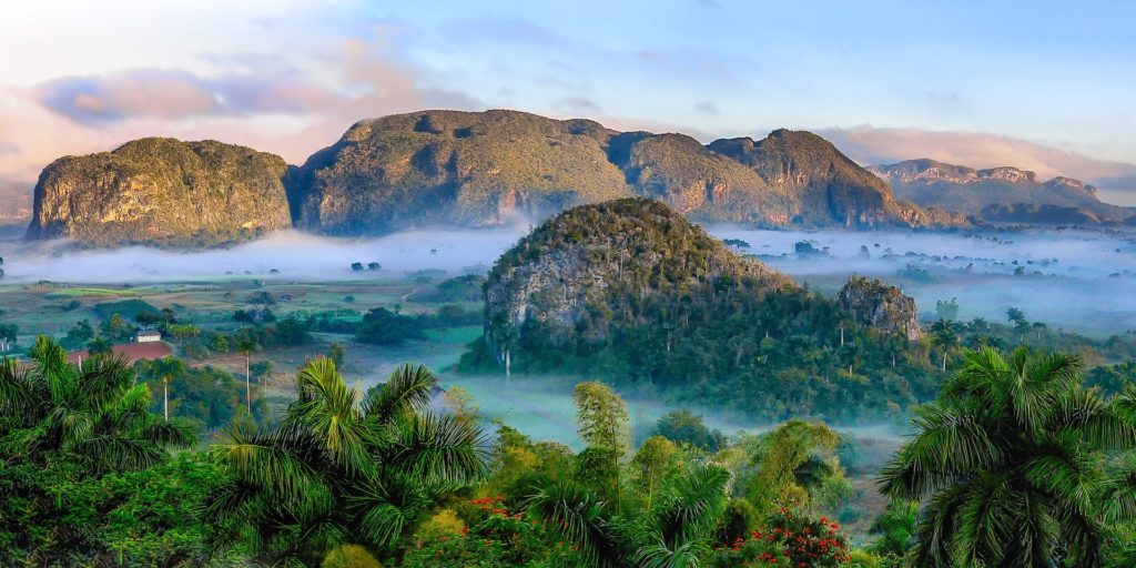 an aerial picture showing the beauty of the best caribbean island to vist, cuba, showing the stunning landscapes of mountains and trees and nature. 