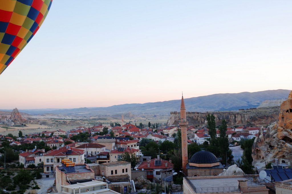 A hot air ballon flying over a city in Turkey 