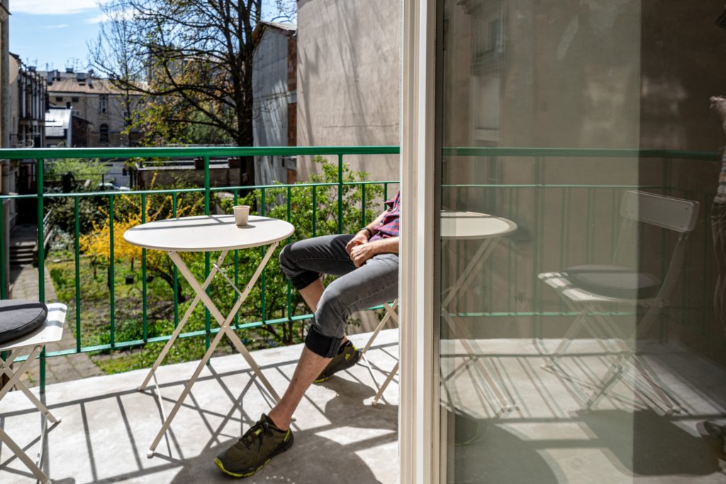 man sat on the balcony with a coffee taking a break from his coworking trip