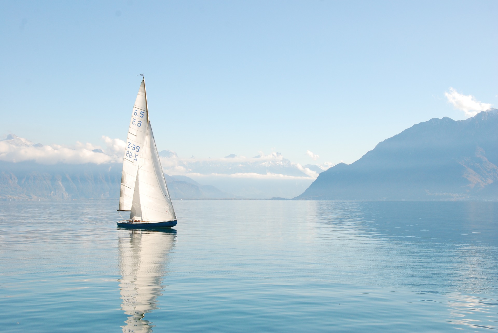 Sailing Trip Guide for Beginners: sailing boat on water in front of mountains