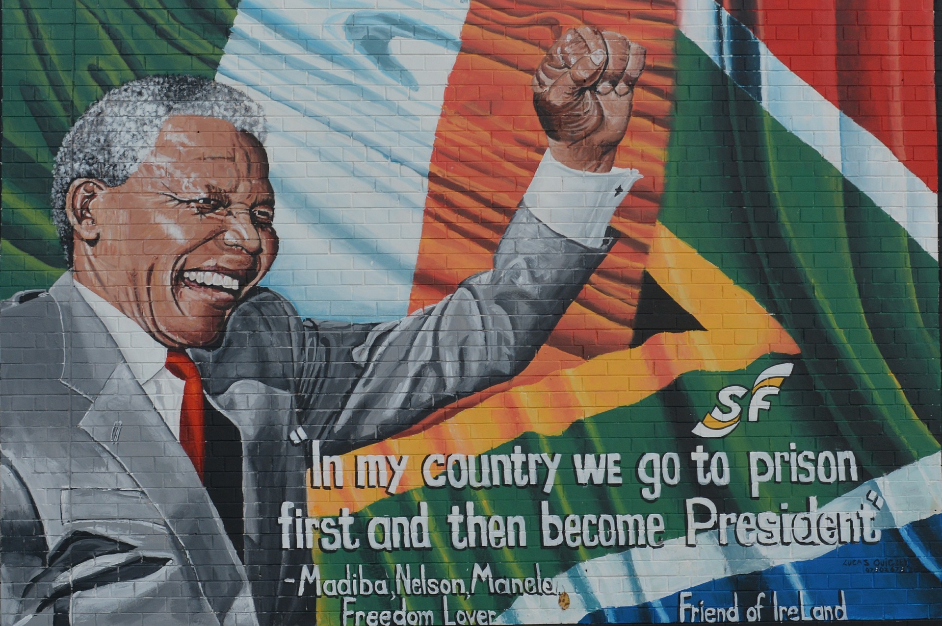 A colorful wall mural of Nelson Mandela with quote 